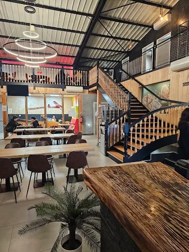 Salle de restaurant Amour de Pizza avec tables et escalier vers la mezzanine
